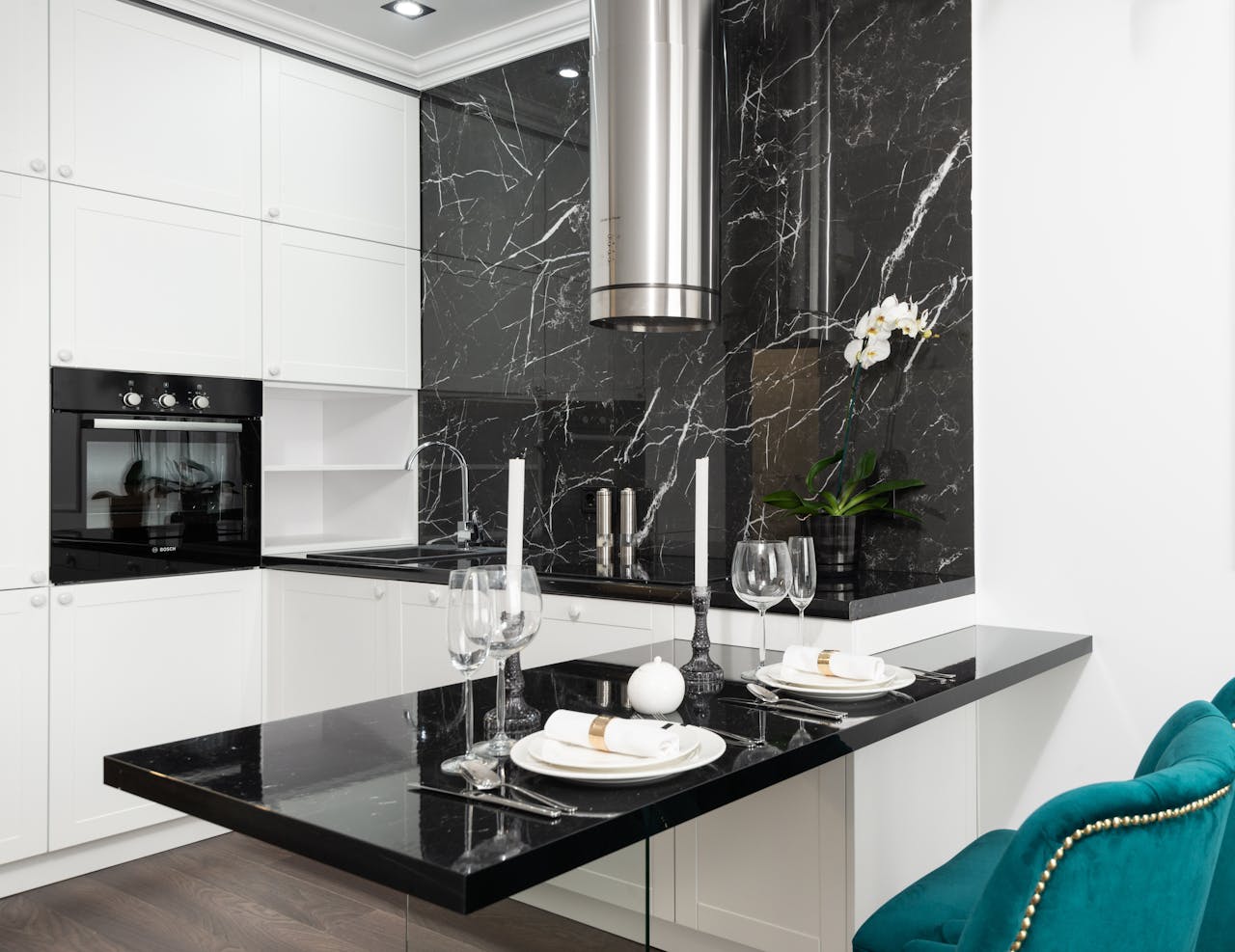 Elegant kitchen with black and white decor, featuring a marble backsplash and sleek appliances.
