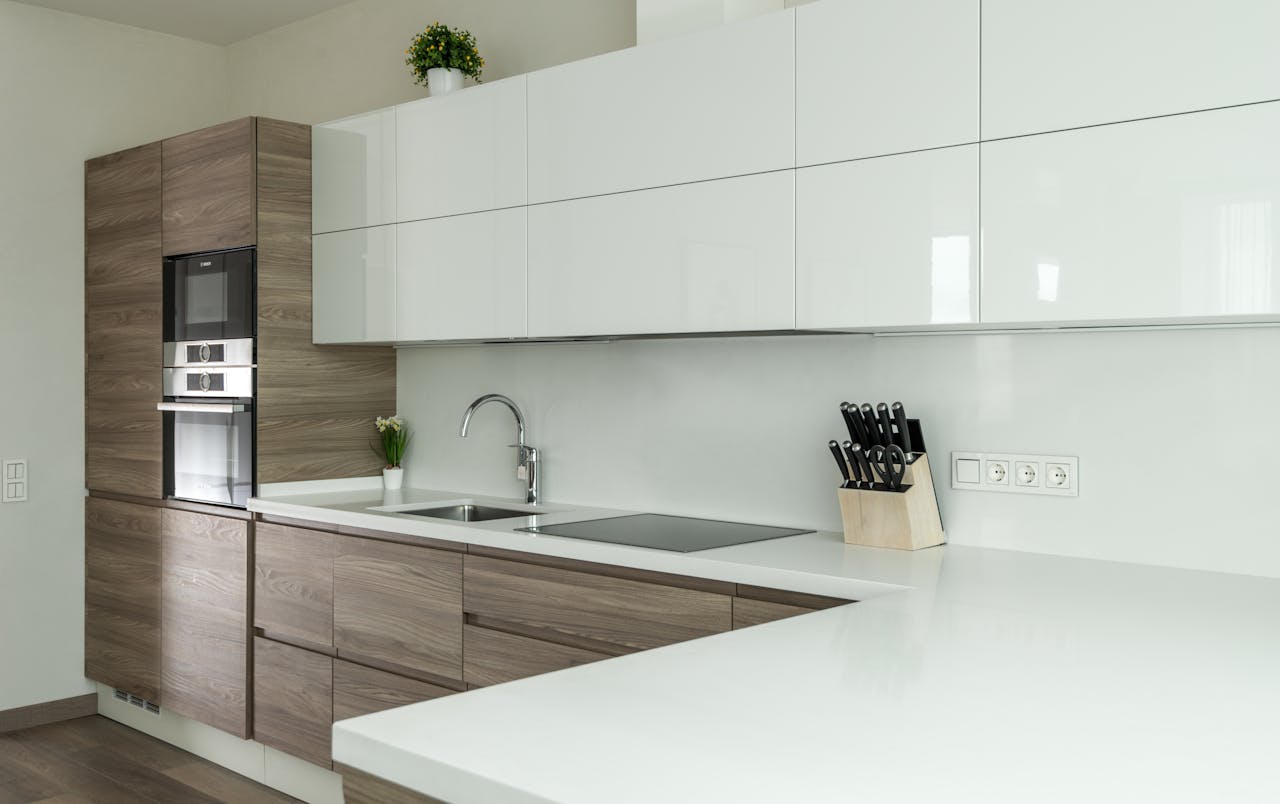 Sleek modern kitchen with wooden and white cabinets, perfect for minimalist interiors.